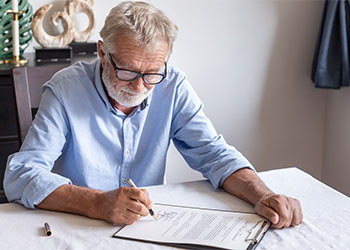 Old Man signing trust document