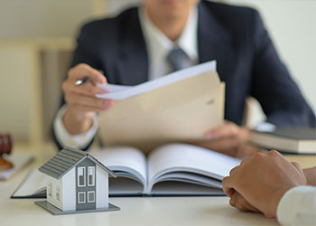 Two people sitting at a desk with paperwork